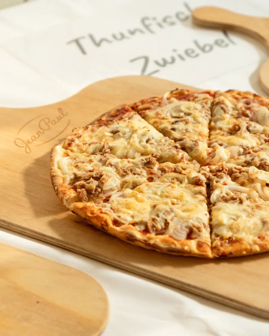 Pizza Thunfisch und Zwiebel auf einem Holzbrett